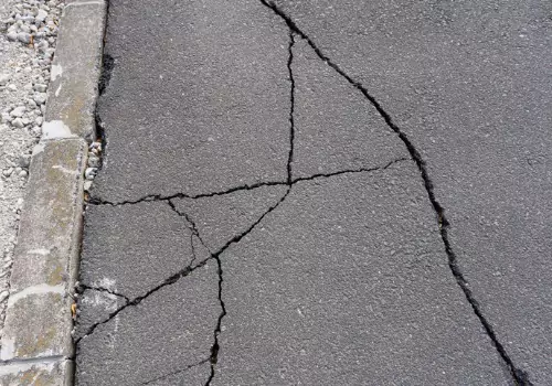 A damaged asphalt roadway requiring Crack Sealing in LaSalle IL