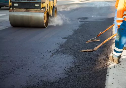Asphalt workers are seen on a job site. Berchtold Asphalt are asphalt Contractors in Moline IL.