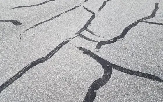 Pavement with multiple filled cracks that has been repaired by Berchtold Asphalt