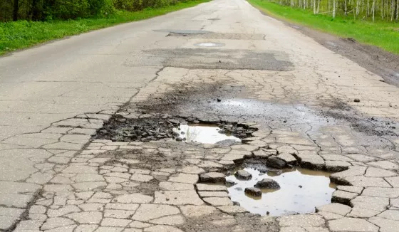 A road with potholes and damaged asphalt