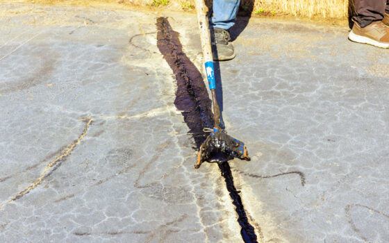 Worker patcher performs coating as part of LaSalle-Peru asphalt services